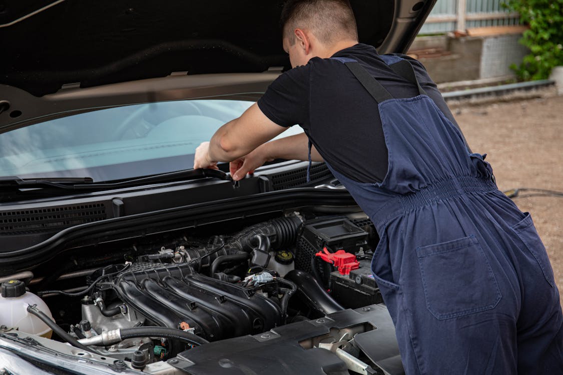 Close-up of mechanic performing detailed car repair work on engine components