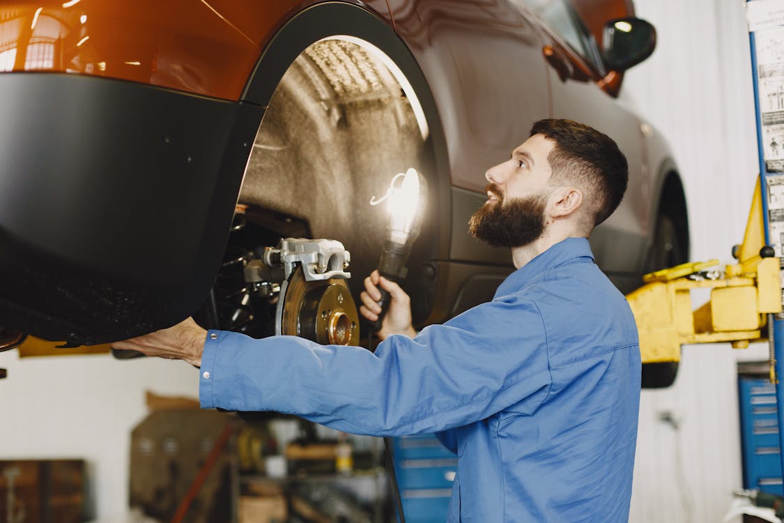 Budget-friendly mobile mechanic carefully inspecting brakes during an honest vehicle assessment